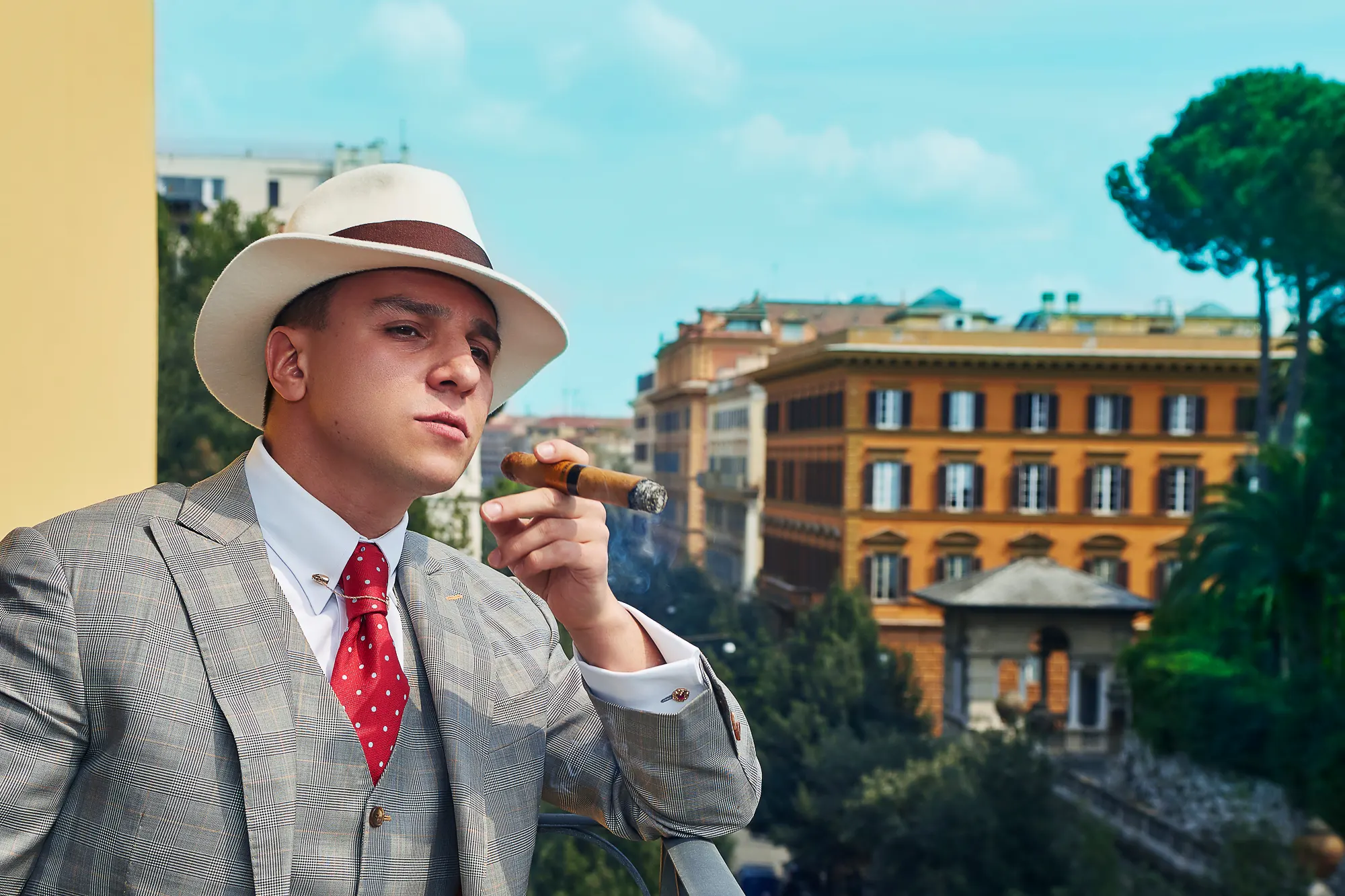 Male portrait with cigar in vintage style suit overlooking historic Rome city architecture