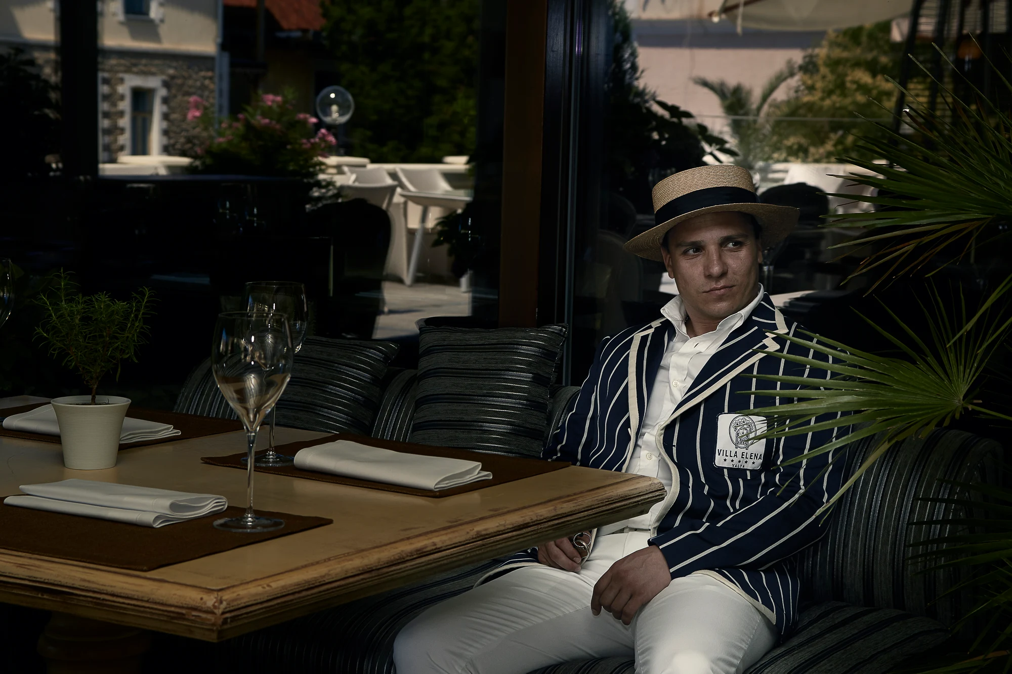 Cinematic portrait of a man in striped blazer sitting at an elegant terrace restaurant (Pavel Manylov)