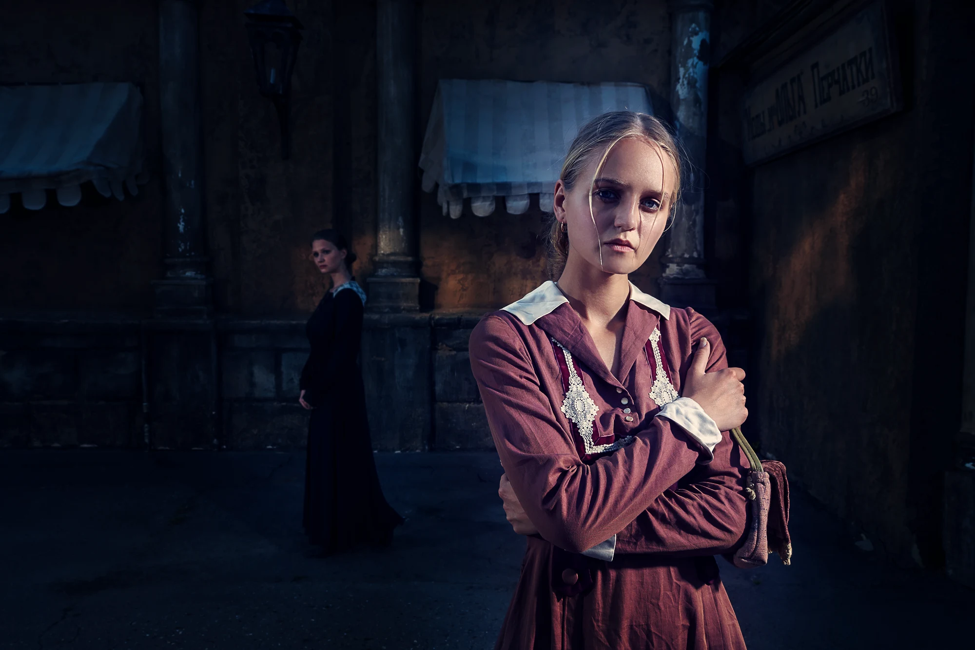 Cinematic portrait of two women in vintage dresses on a moody night street