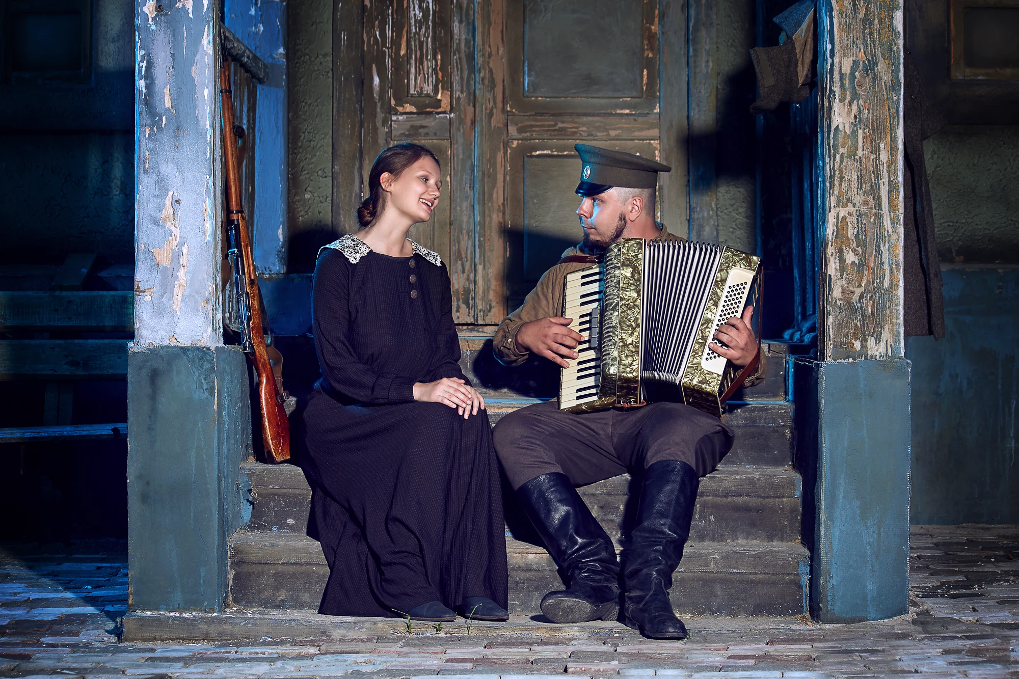 Romantic cinematic scene of a soldier playing accordion for a woman on old steps