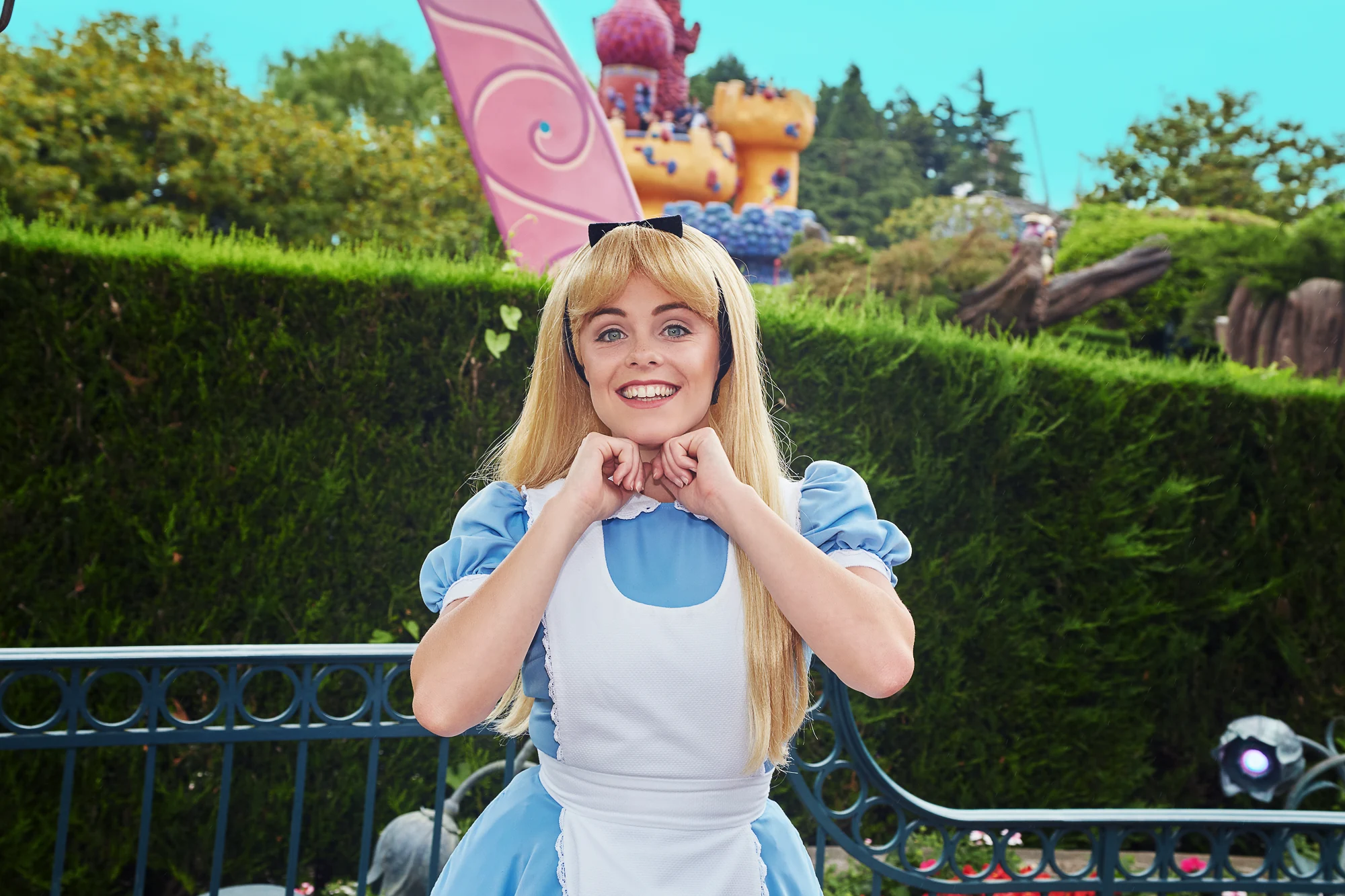 Cosplay portrait of Alice in Wonderland character in a colorful theme park setting