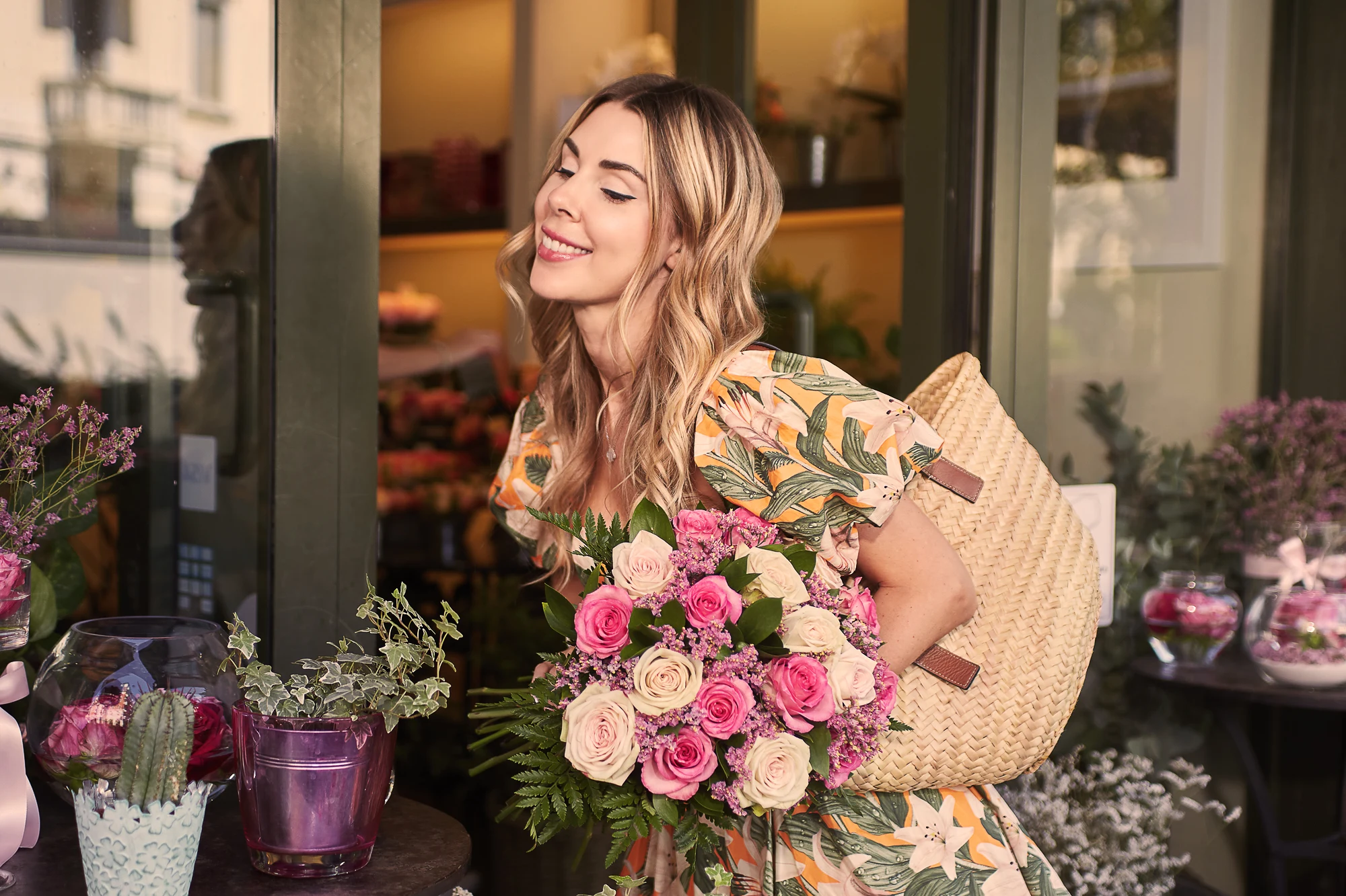 Smiling woman with bouquet of roses in front of a cozy flower shop in Milan (Mila Maurus)