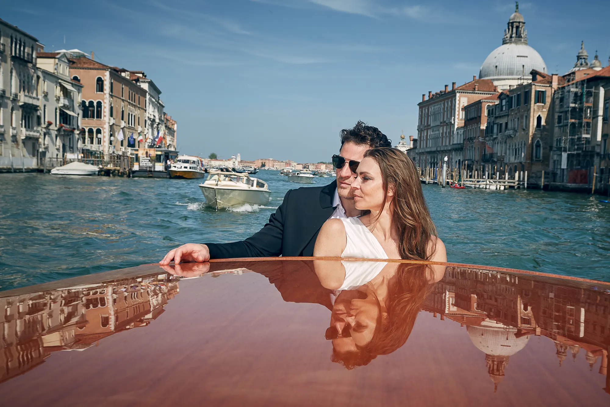 Engagement photographer in Venice Italy photographing romantic couple on wooden water taxi on Grand Canal