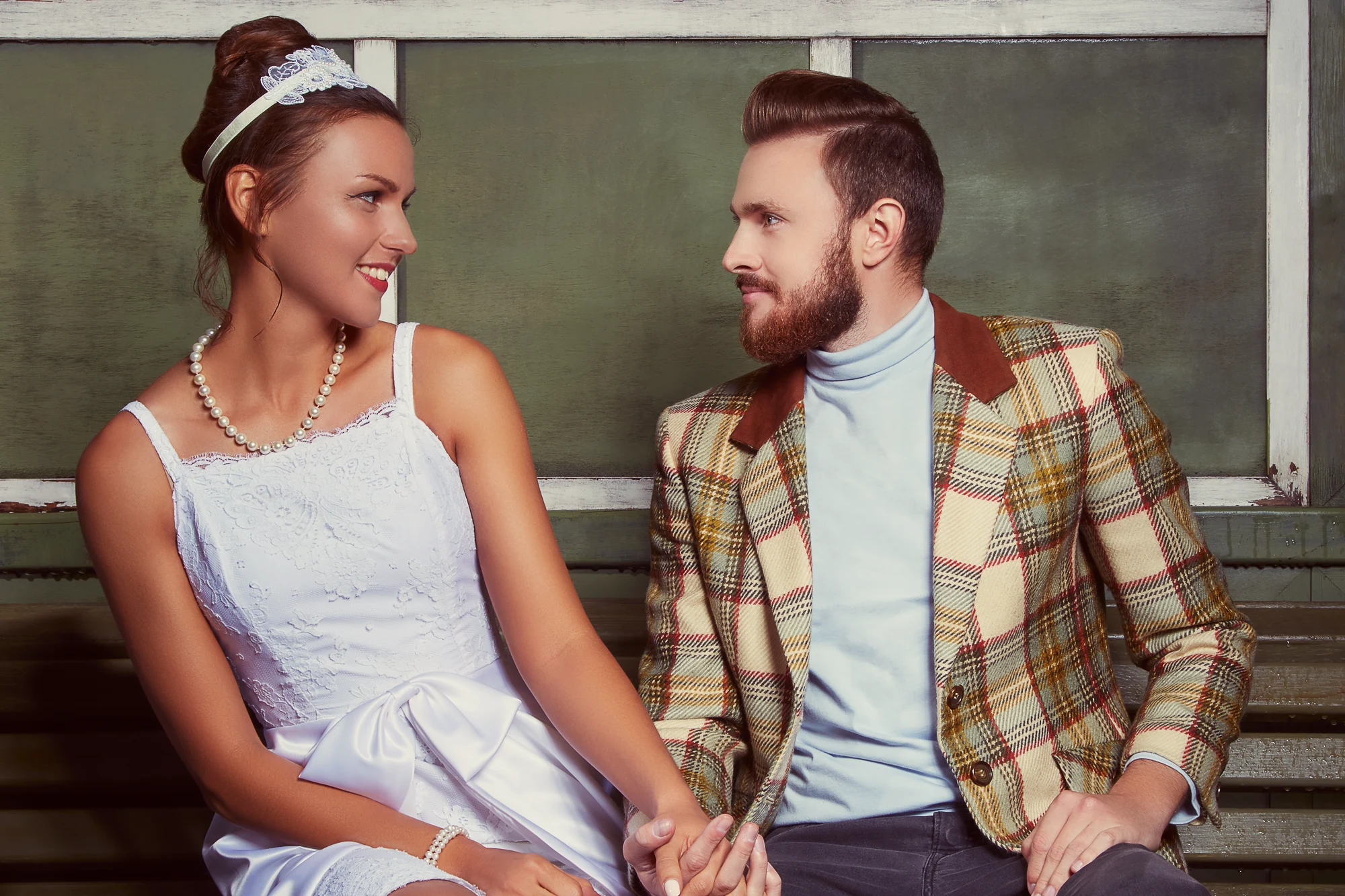 Retro inspired wedding couple portrait sitting on bench in vintage setting