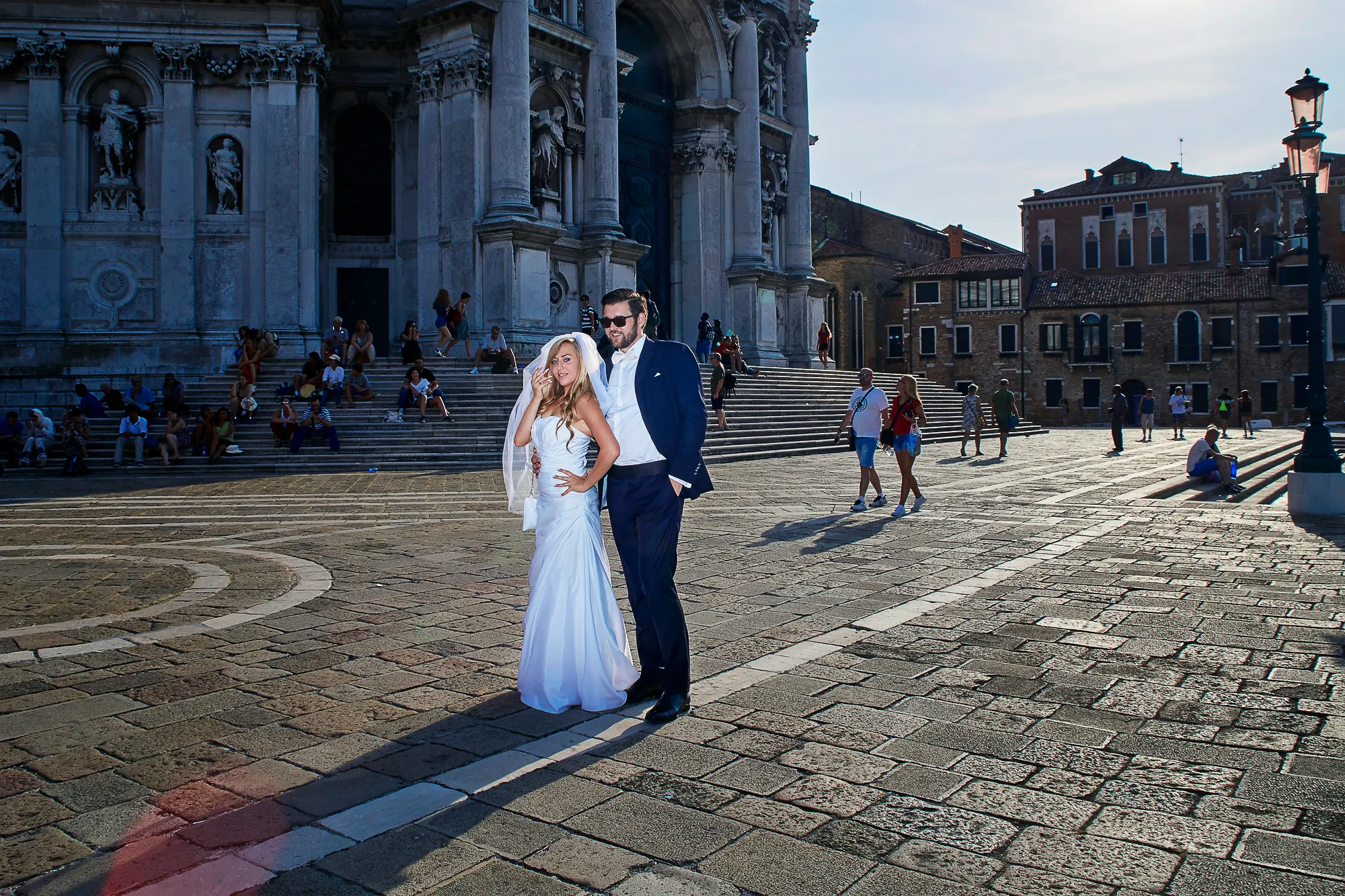 Bride and groom posing on square near grand baroque church, wedding photographer in Venice Italy