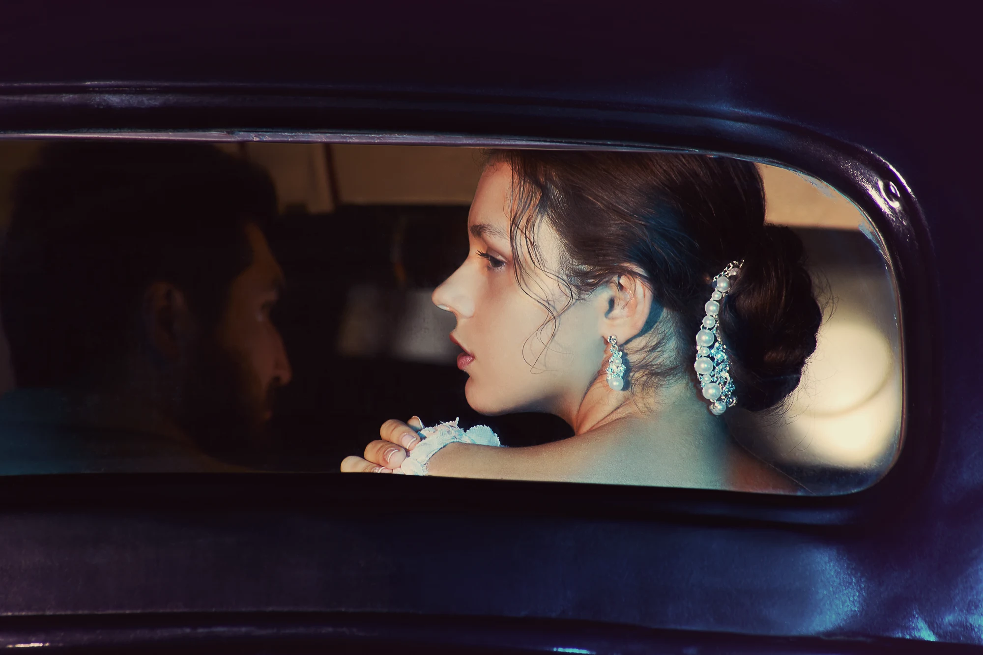 Wedding photographer in Italy shooting stylish bride in vintage car with groom in background