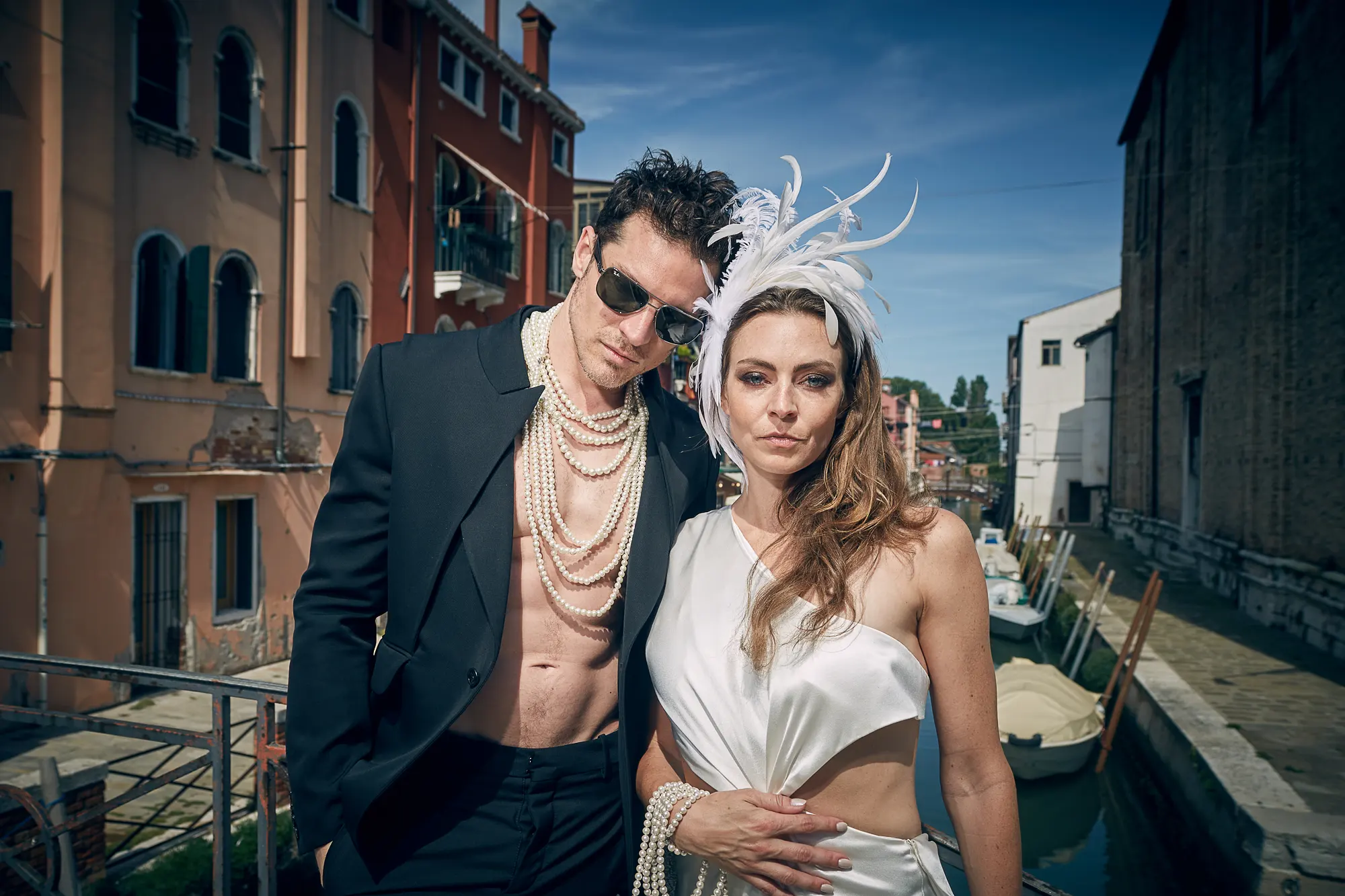 Stylish wedding couple in Venice posing by canal in modern fashion editorial style