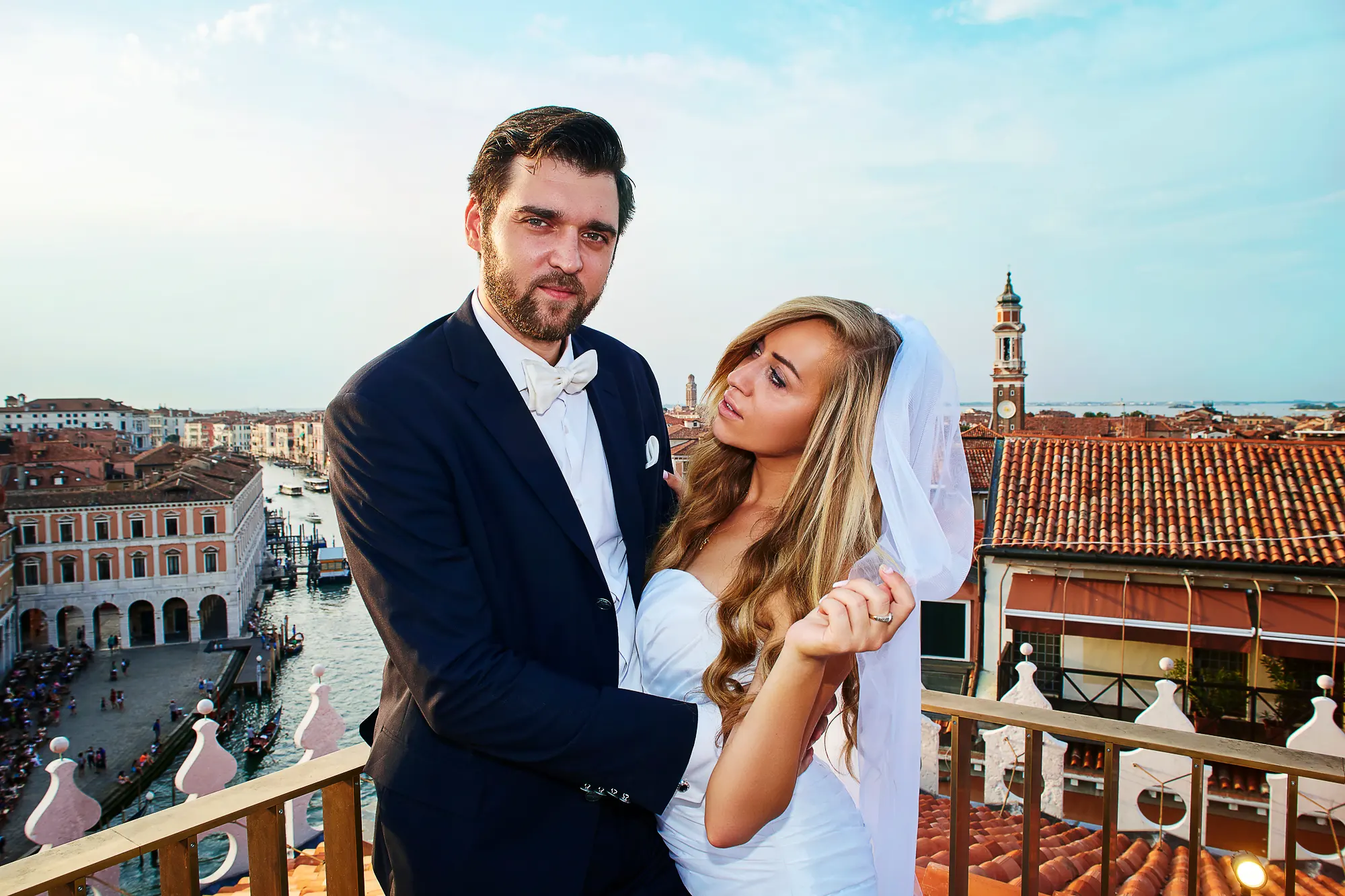 Bride and groom on rooftop terrace overlooking the Grand Canal in Venice Italy
