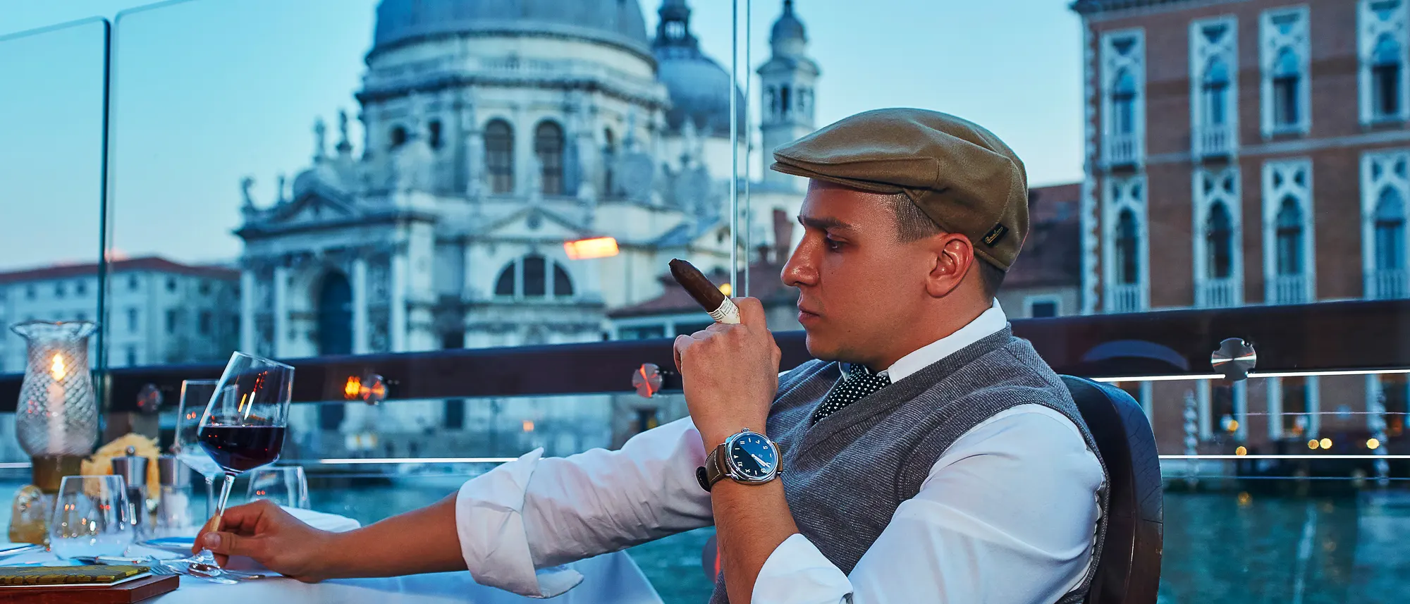 Man in flat cap smoking cigar at elegant restaurant terrace on the Grand Canal, photographer in Venice