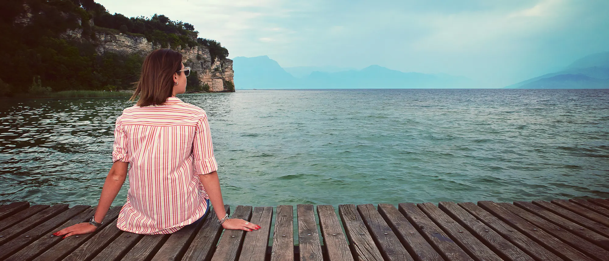 Индивидуальная фотосессия в Вероне — женщина на деревянном пирсе у озера